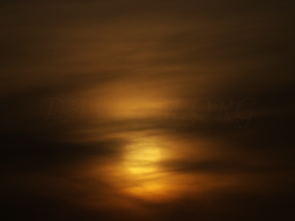 雲にくるまれた夕陽の写真